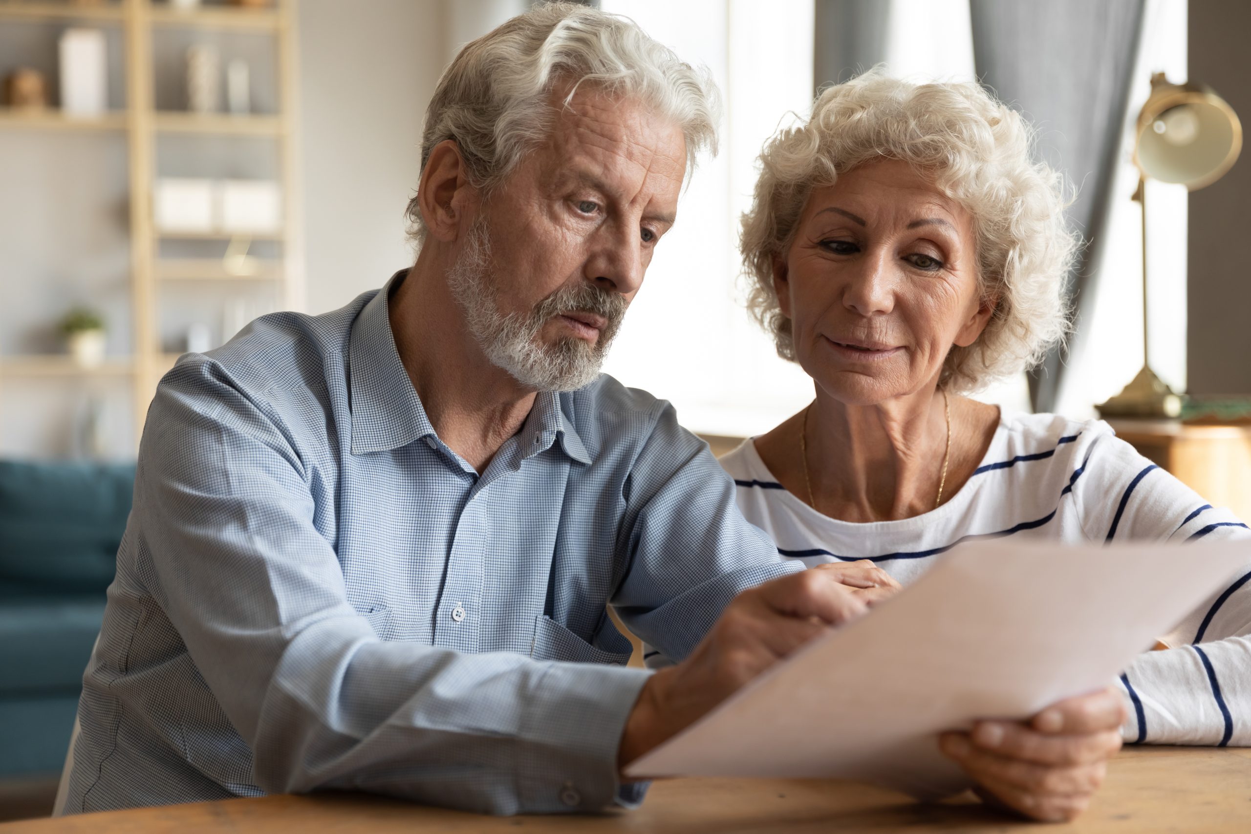 Focused,Elderly,70s,Married,Couple,Sit,At,Table,At,Home,